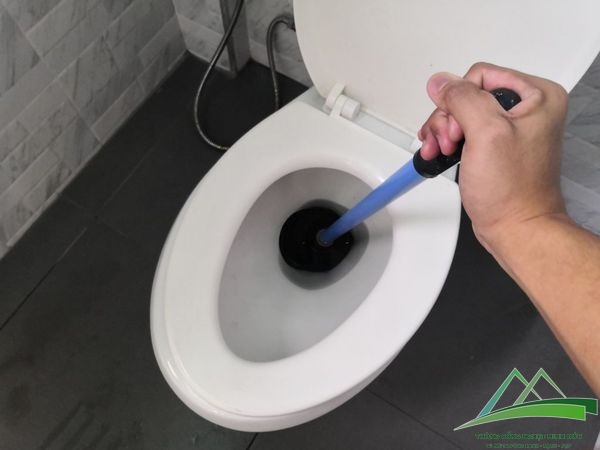 thông bồn cầu bị tắc bởi vật cứng bằng cây thụt